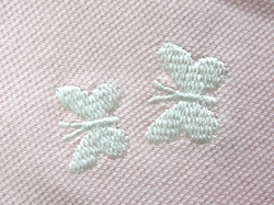 Detail výšivky motýlků na kojeneckém triku s krátkým rukávem