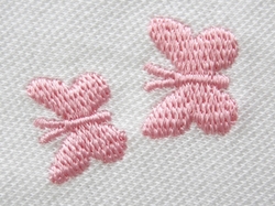 Detail výšivky motýlků na kojeneckém triku