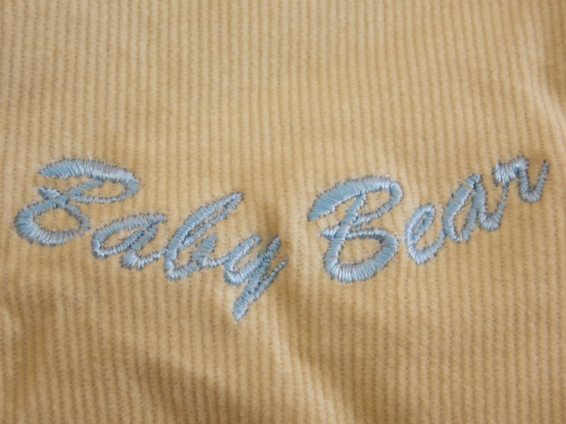 Detail výšivky na kojeneckých zateplených kalhotách pro chlapečky